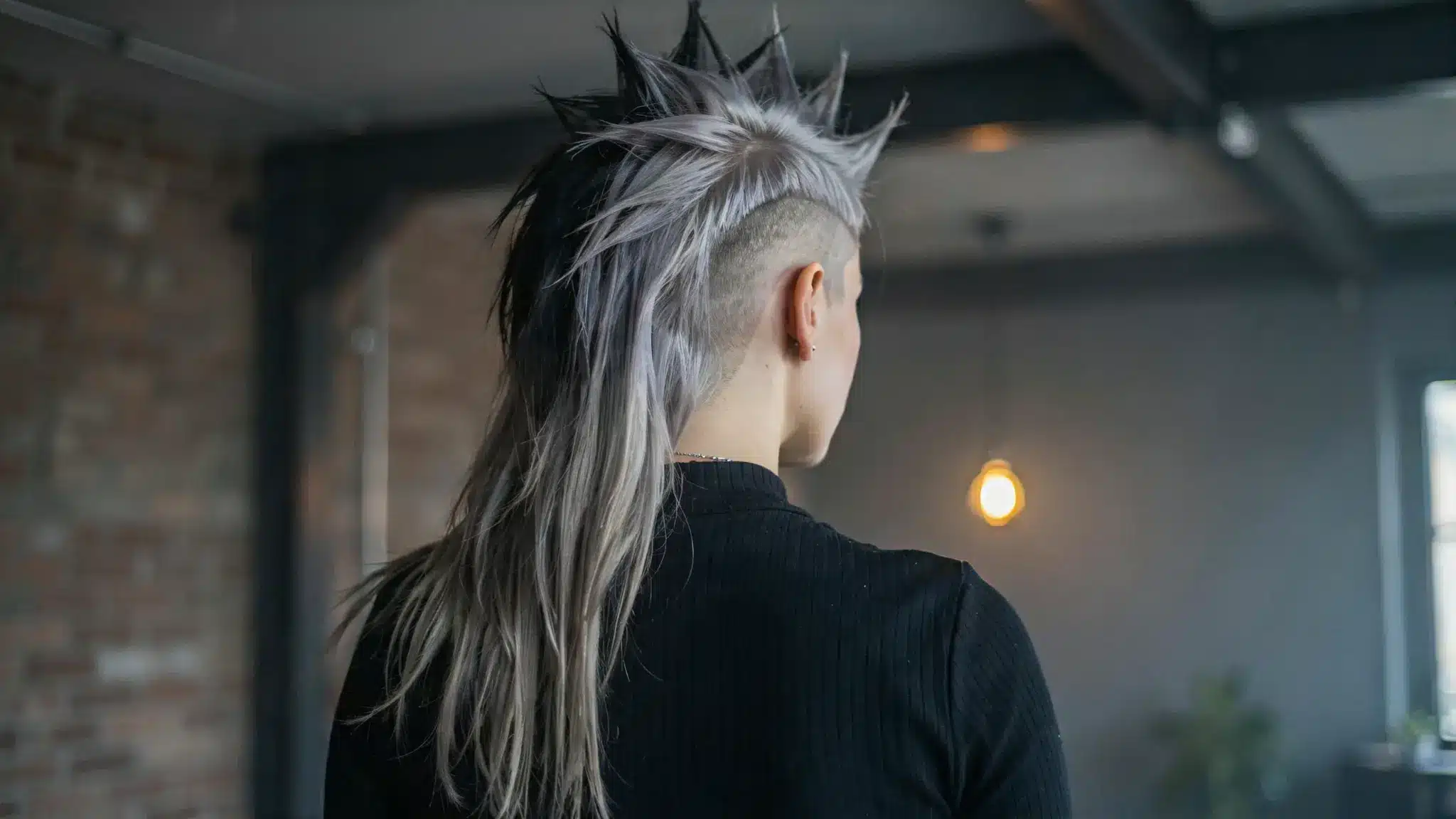 Back view of a deathhawk hairstyle with spiked silver top and shaved sides.
