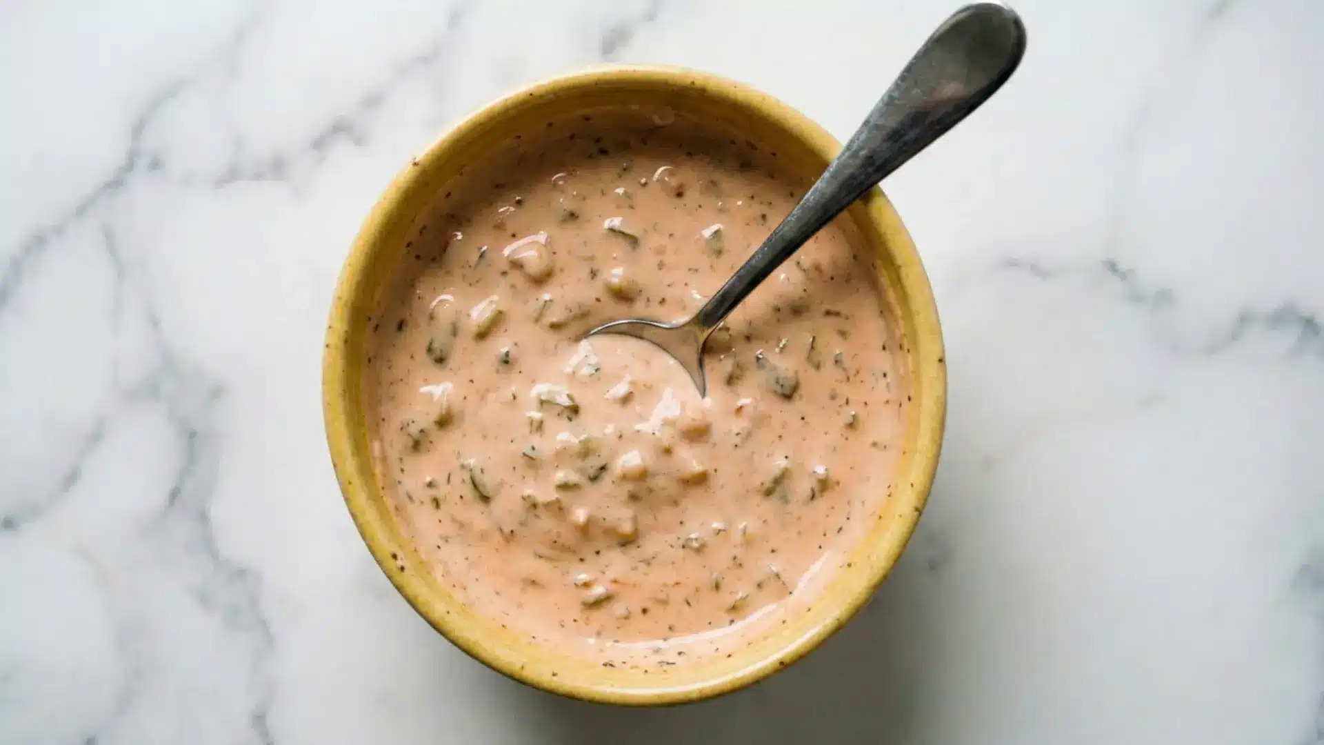 homemade big mac sauce recipe in a yellow bowl with pickle relish and creamy pinkish orange color on marble surface