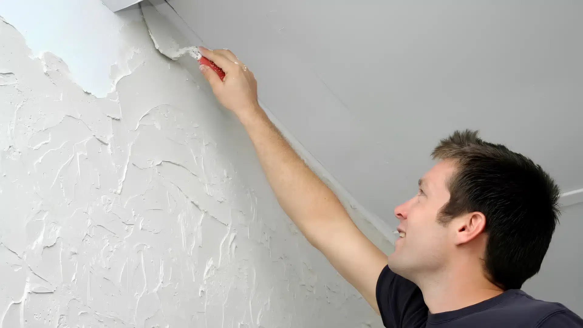 Man using skrip trowel finish to texture a ceiling