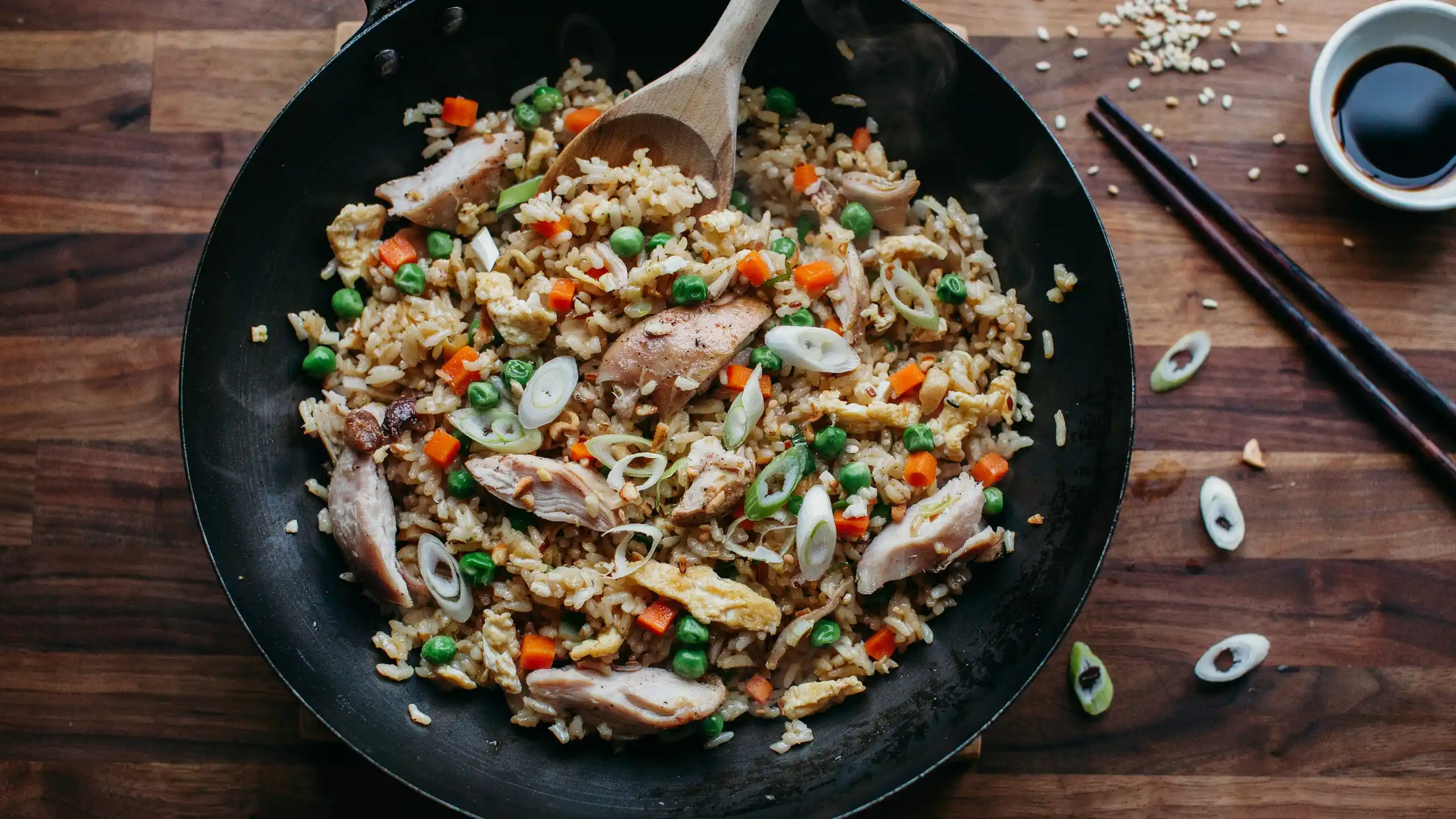 A pan filled with chicken fried rice, mixed with colorful vegetables and fluffy rice, ready to be served.