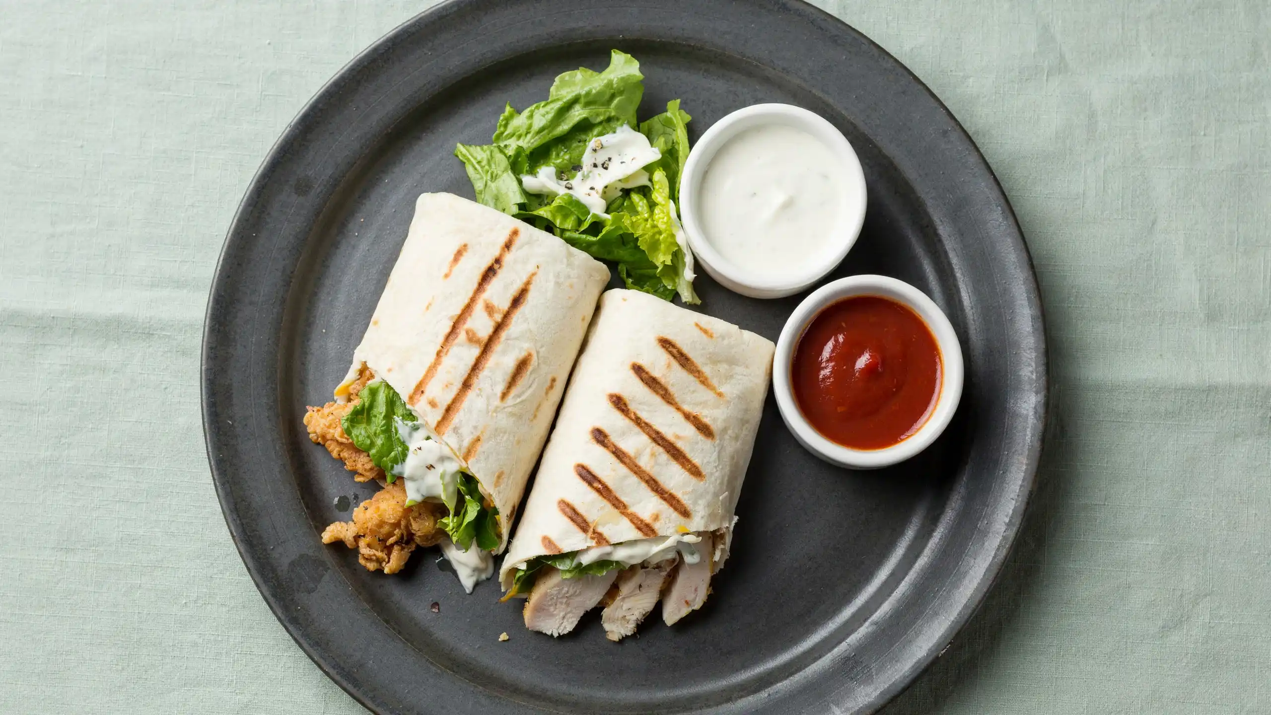 A serving plate displaying tender buffalo chicken and crisp lettuce wraps, arranged attractively for a meal.
