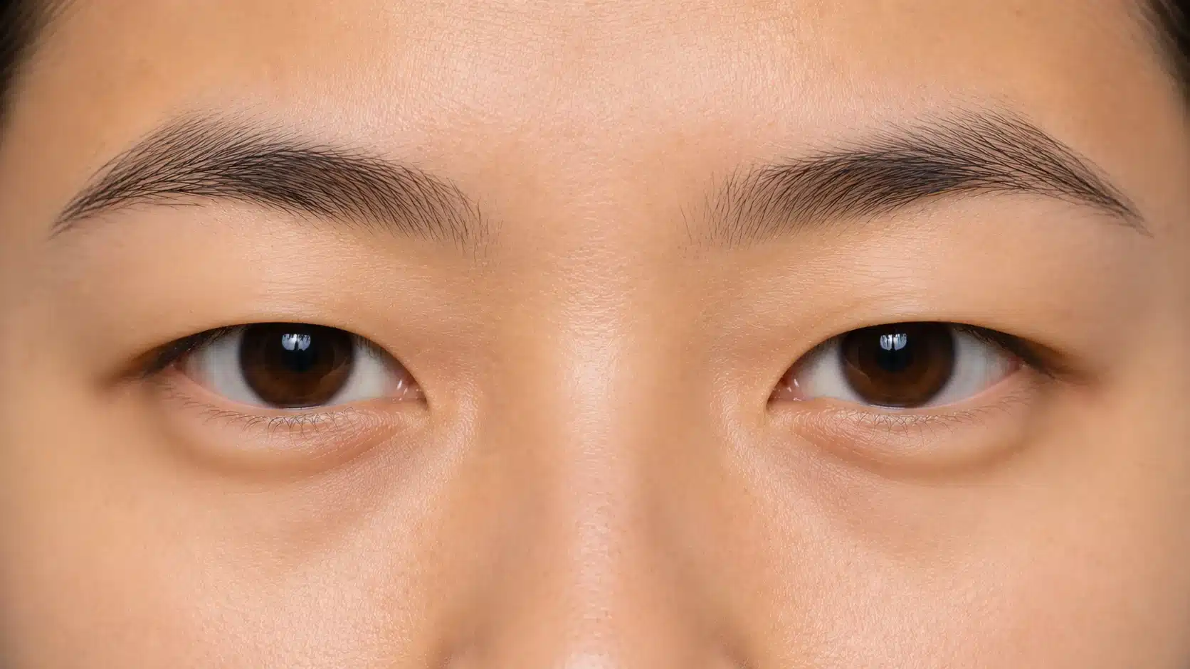 Close-up of a woman with brown monolid eyes and a petite nose, highlighting her distinct appearance.