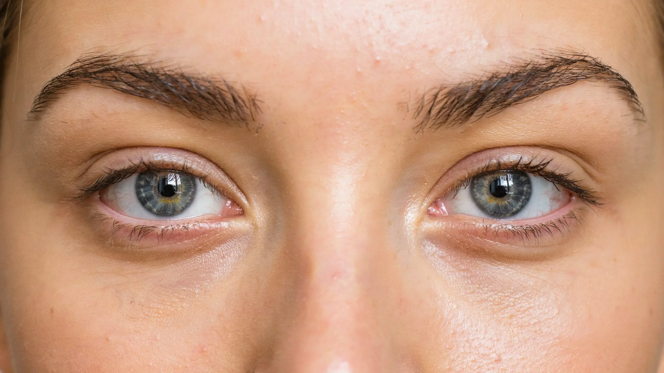 Close-up of a woman with brown monolid eyes and a petite nose, highlighting her distinct appearance.