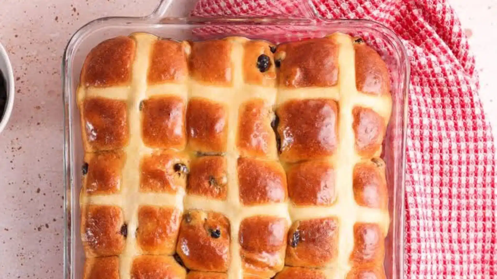 cooled brioche buns stored in a glass container and freezer bag on a wooden kitchen counter