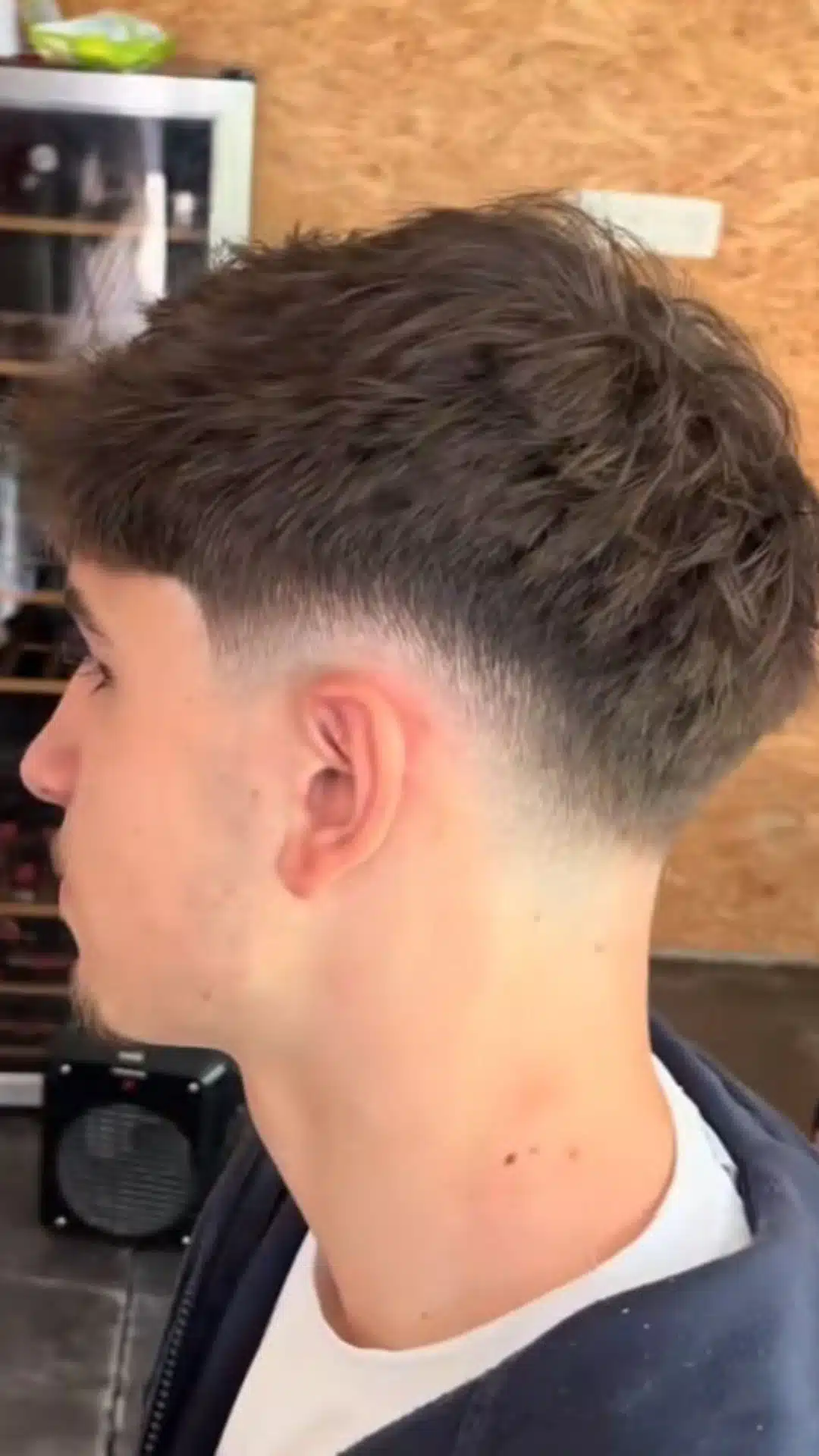 Side and back view of a man with a textured crop taper haircut featuring short textured hair on top