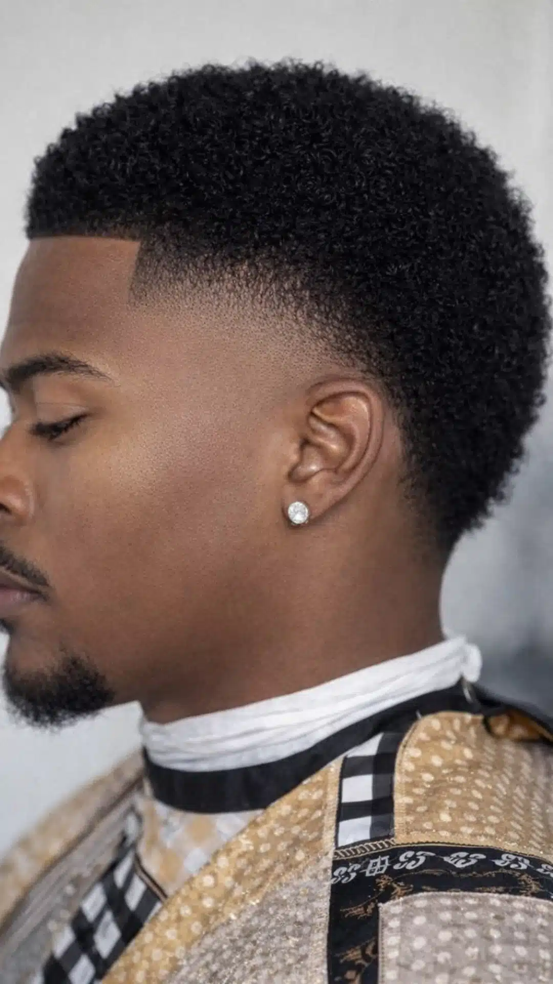 Side profile of a man with an afro taper haircut featuring tightly curled hair